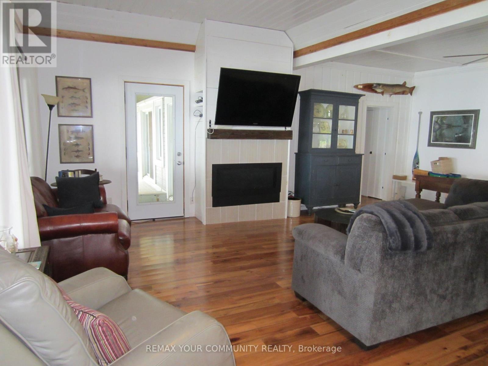 2 walkouts in Living Room / Propane Fireplace - 6576 Quarry Point Road, Ramara, ON - Indoor Photo Showing Living Room With Fireplace