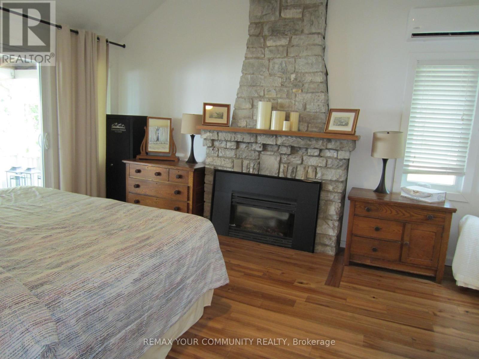 Stone Propane Fireplace - 6576 Quarry Point Road, Ramara, ON - Indoor Photo Showing Bedroom With Fireplace
