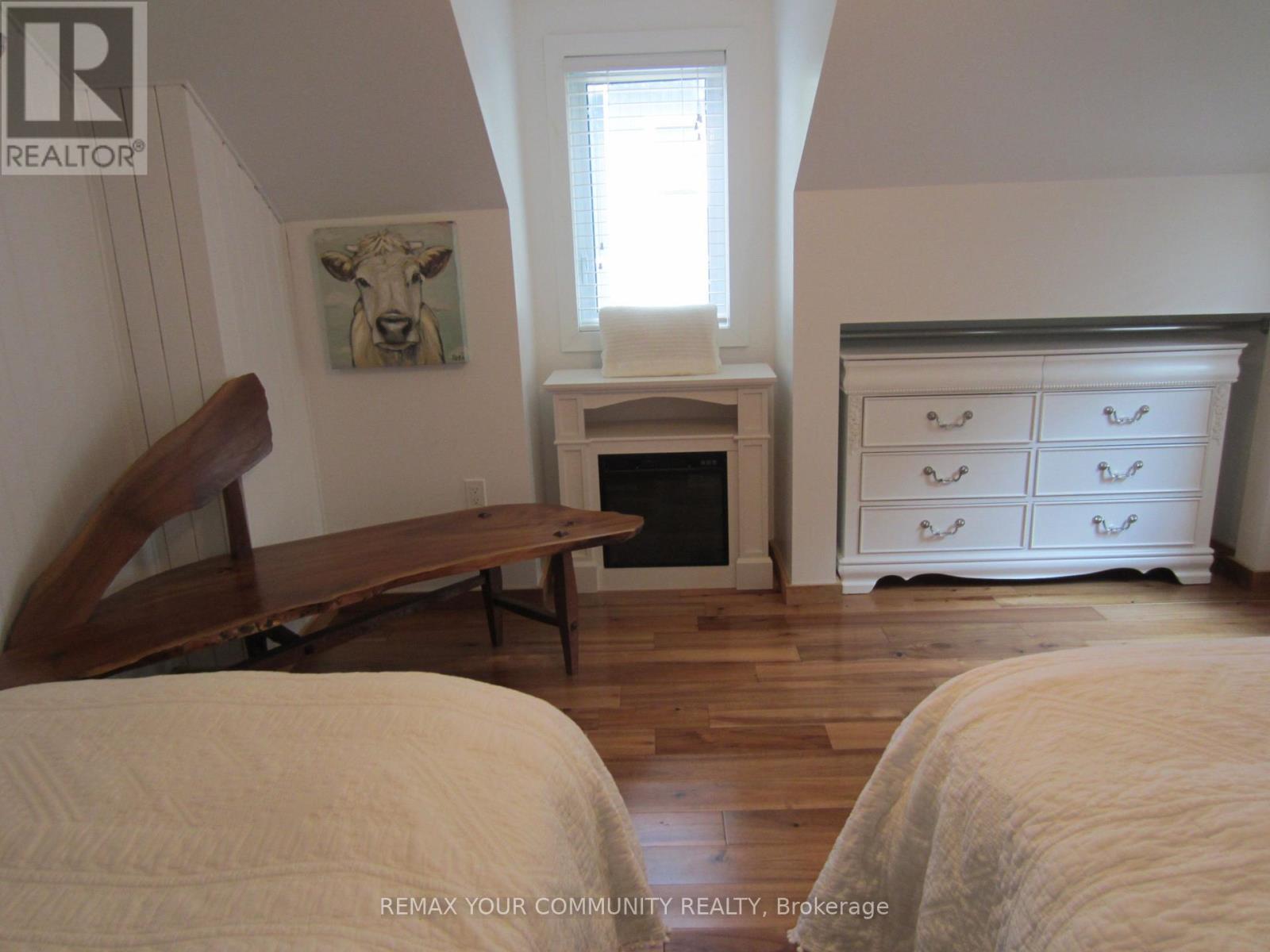 Electric fireplace and custom rough hewn bench - 6576 Quarry Point Road, Ramara, ON - Indoor Photo Showing Bedroom