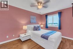 Wood-finish flooring, white trim, and a ceiling fan with integrated lighting - 