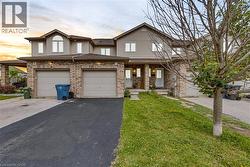 Exterior featuring brick and siding finishes, multiple windows, and an attached garage - 