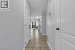 Hallway with neutral tone tile flooring and light-colored walls - 