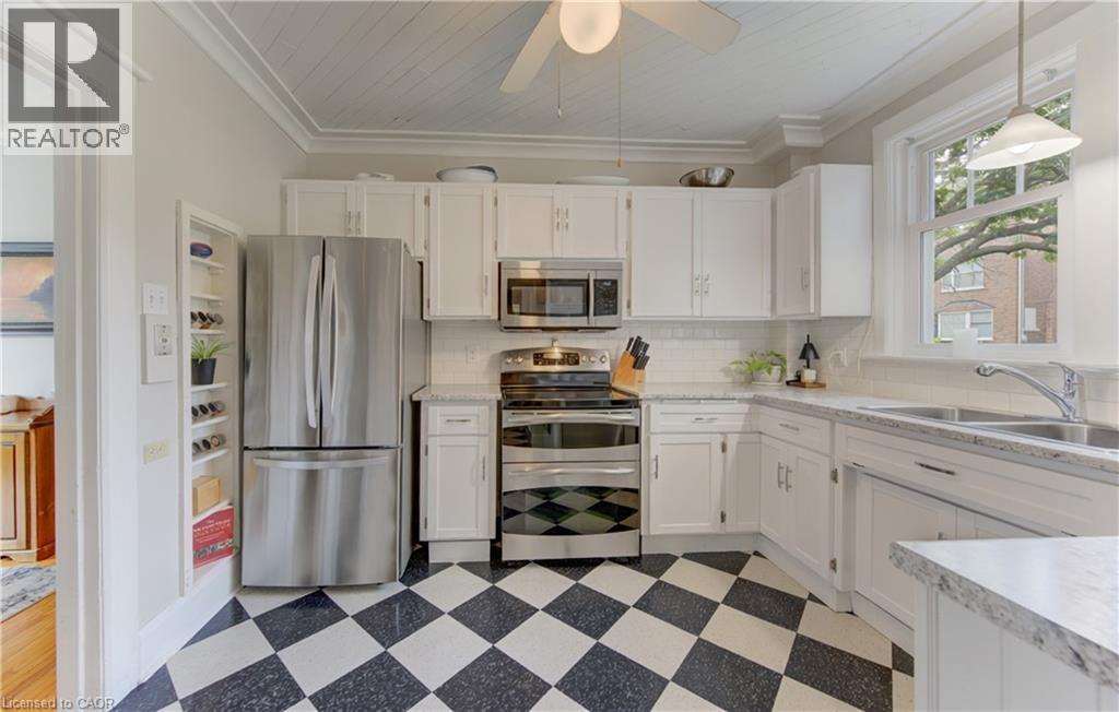 Kitchen featuring white cabinetry, stainless steel appliances, speckled countertops, and a white subway tile backsplash - 150 Union Boulevard, Kitchener, ON - Indoor Photo Showing Kitchen With Double Sink