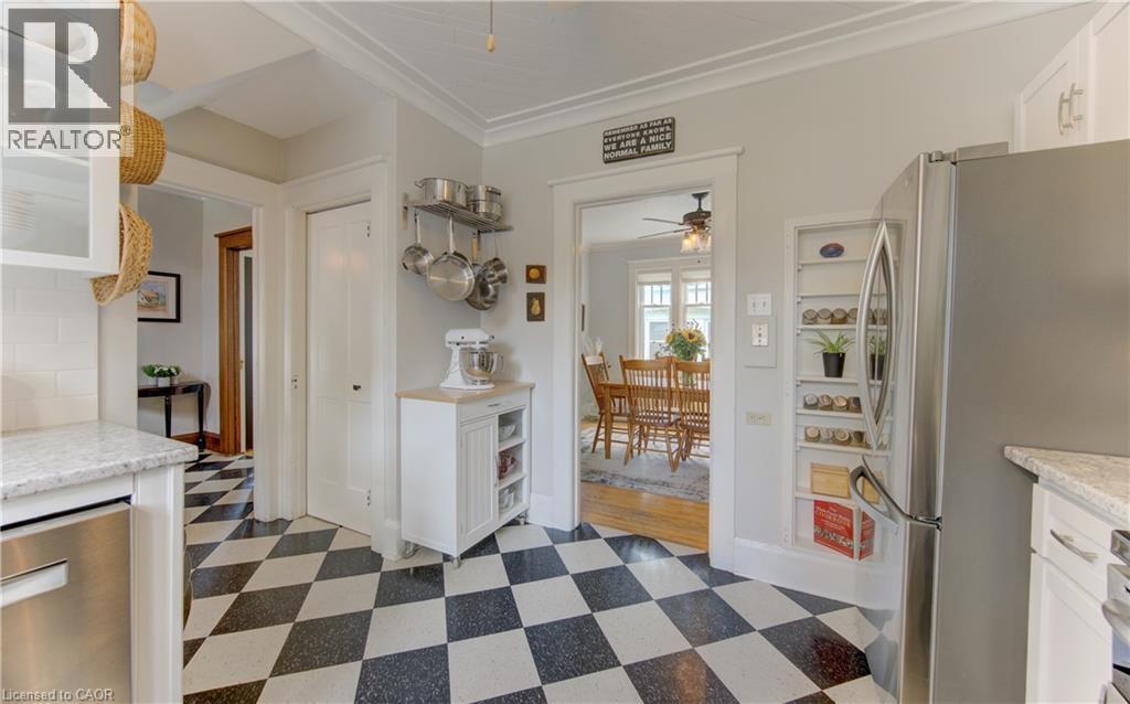 Black and white checkered flooring, stainless steel appliances, built-in shelving, white cabinetry, and light-colored countertops - 150 Union Boulevard, Kitchener, ON - Indoor Photo Showing Other Room