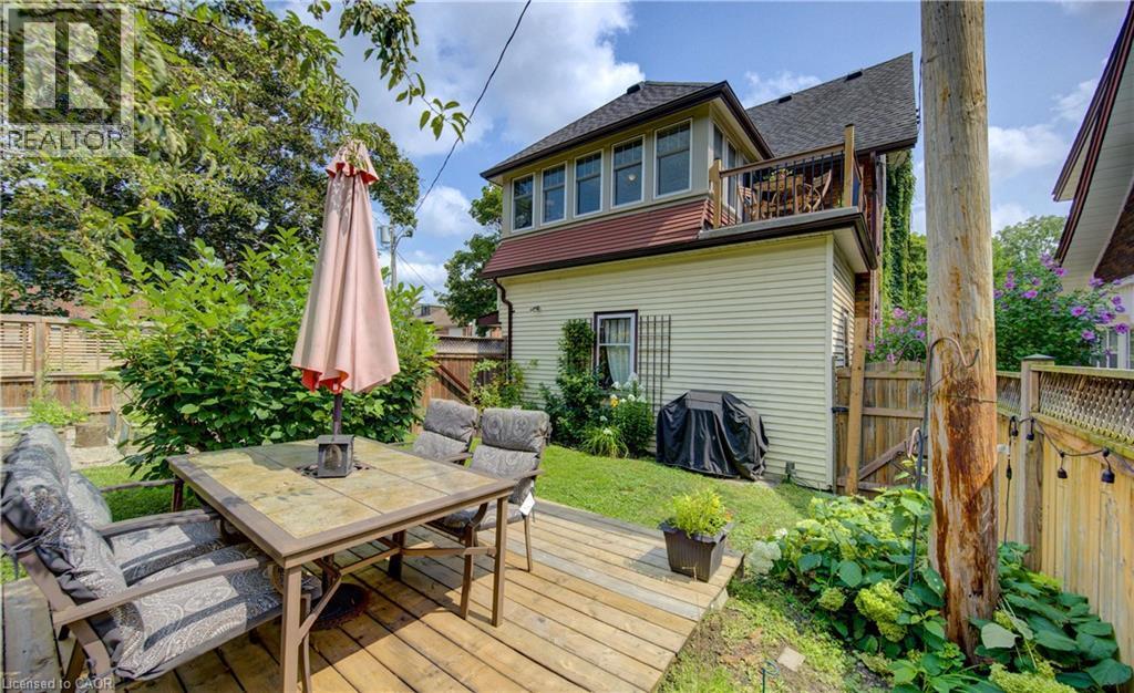 Expansive wood deck with a built-in outdoor dining area, surrounded by lush landscaping and a privacy fence - 150 Union Boulevard, Kitchener, ON - Outdoor With Deck Patio Veranda With Exterior