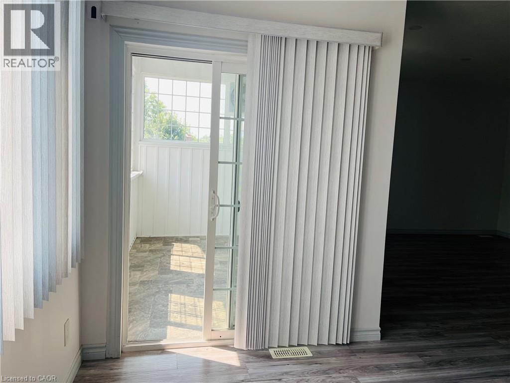 Sliding glass patio door with vertical blinds - 83 Keewatin Avenue, Kitchener, ON - Indoor Photo Showing Other Room