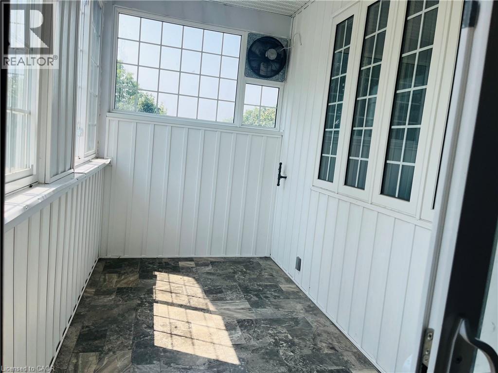 Room with paneled walls and dark-toned flooring - 83 Keewatin Avenue, Kitchener, ON - With Exterior