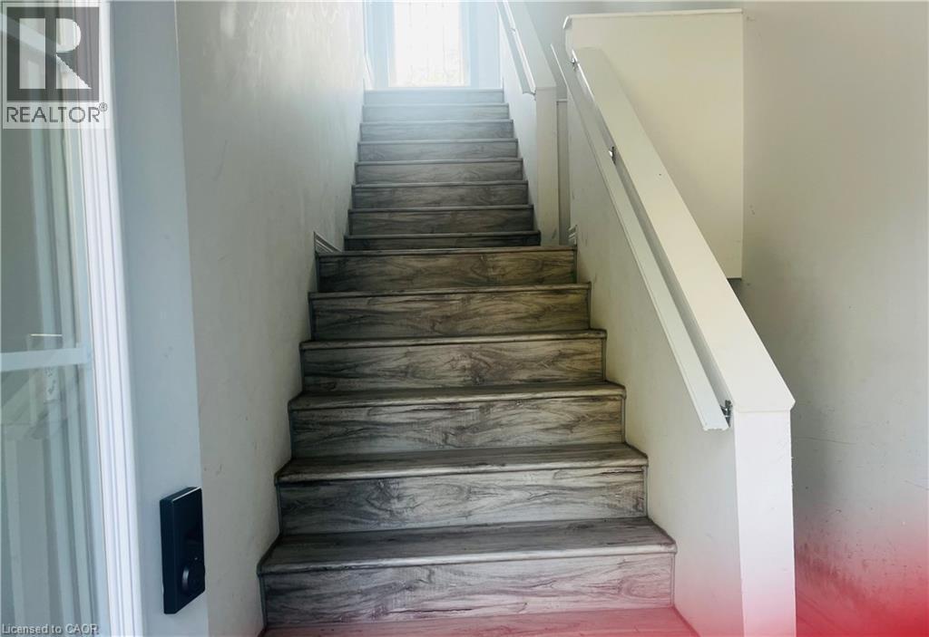 Additional content The image shows a staircase with wood-finish treads and white painted walls with a handrail, but lacks sufficient architectural detail, material specification, or distinctive featu - 83 Keewatin Avenue, Kitchener, ON - Indoor Photo Showing Other Room