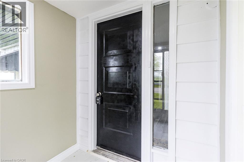 Panelized black entry door with a white frame and sidelight - 15 Spiers Crescent, Cambridge, ON - With Exterior