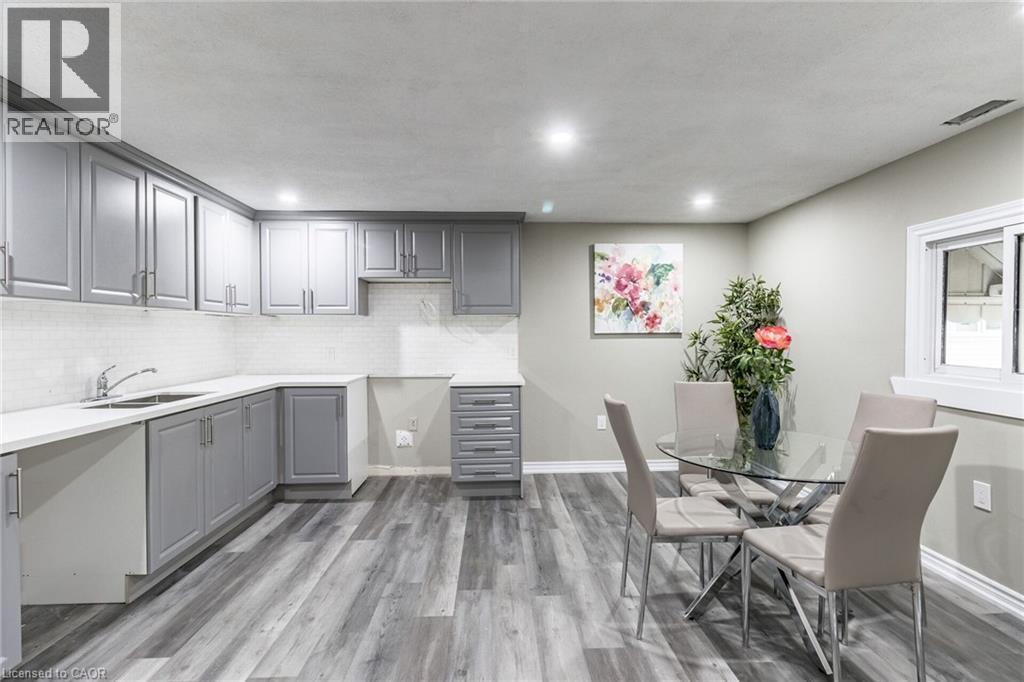Grey shaker-style cabinetry, white subway tile backsplash, white countertops, wood-finish flooring, and recessed lighting - 15 Spiers Crescent, Cambridge, ON - Indoor