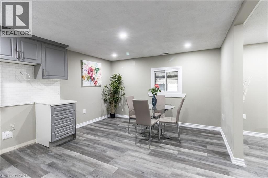 Grey shaker cabinetry, white subway tile backsplash, wood-finish flooring, recessed lighting, and a white-framed window - 15 Spiers Crescent, Cambridge, ON - Indoor