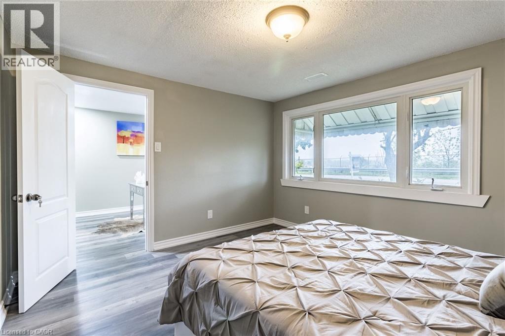 Wood-finish flooring, white trim details, and a multi-pane window with a deep sill - 15 Spiers Crescent, Cambridge, ON - Indoor Photo Showing Bedroom