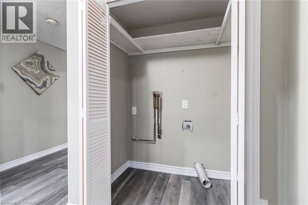 Utility closet with bifold louvered doors, wood-finish flooring, and internal shelving - 15 Spiers Crescent, Cambridge, ON - Indoor Photo Showing Other Room