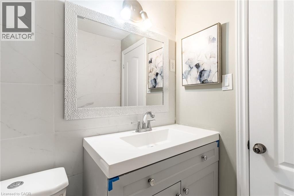 Vanity with a built-in sink, chrome faucet, and integrated lighting - 15 Spiers Crescent, Cambridge, ON - Indoor Photo Showing Bathroom