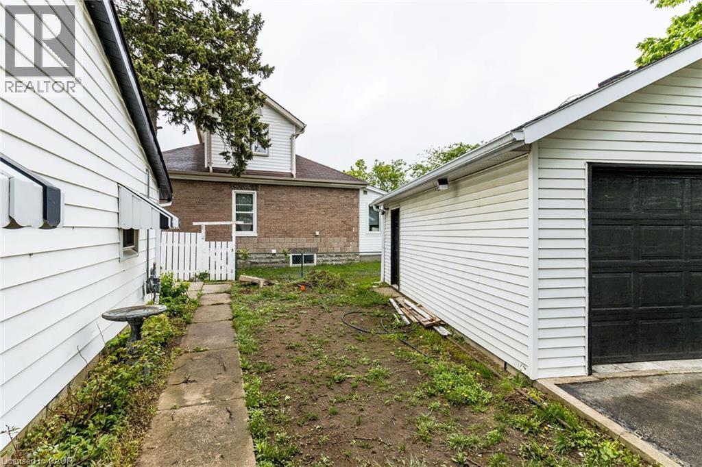 Detached garage with white siding and dark garage door - 15 Spiers Crescent, Cambridge, ON - Outdoor With Exterior