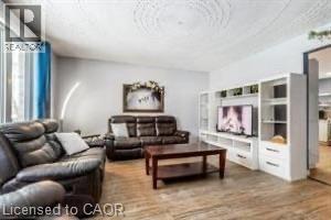 Wood-finish flooring throughout, recessed ceiling detail, and a built-in media center with shelving - 510 Oakridge Place, Waterloo, ON - Indoor Photo Showing Living Room