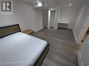 Wood-finish flooring with white baseboards, recessed lighting, and white walls - 510 Oakridge Place, Waterloo, ON - Indoor Photo Showing Bedroom