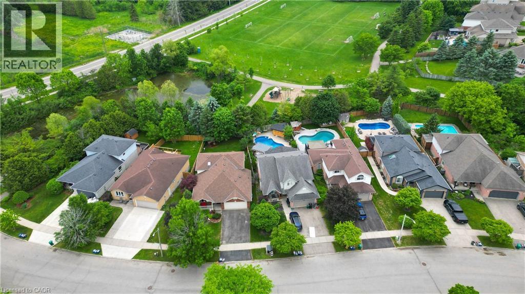 Aerial perspective showcasing a residential street with diverse home exteriors, private driveways, and expansive green spaces - 599 Coldstream Drive, Waterloo, ON - Outdoor With View