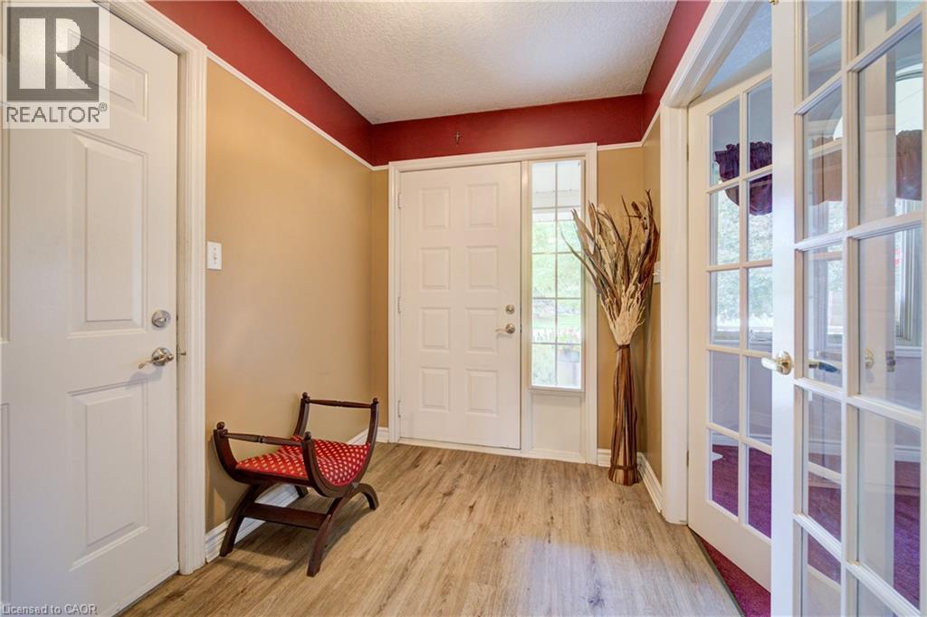 Entryway featuring wood-finish flooring, a white paneled front door with a sidelight, and French doors - 599 Coldstream Drive, Waterloo, ON - Indoor Photo Showing Other Room
