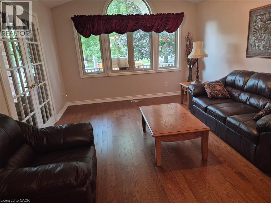 Hardwood flooring, arched transom window, multiple pane windows, and a set of French doors - 599 Coldstream Drive, Waterloo, ON - Indoor Photo Showing Living Room