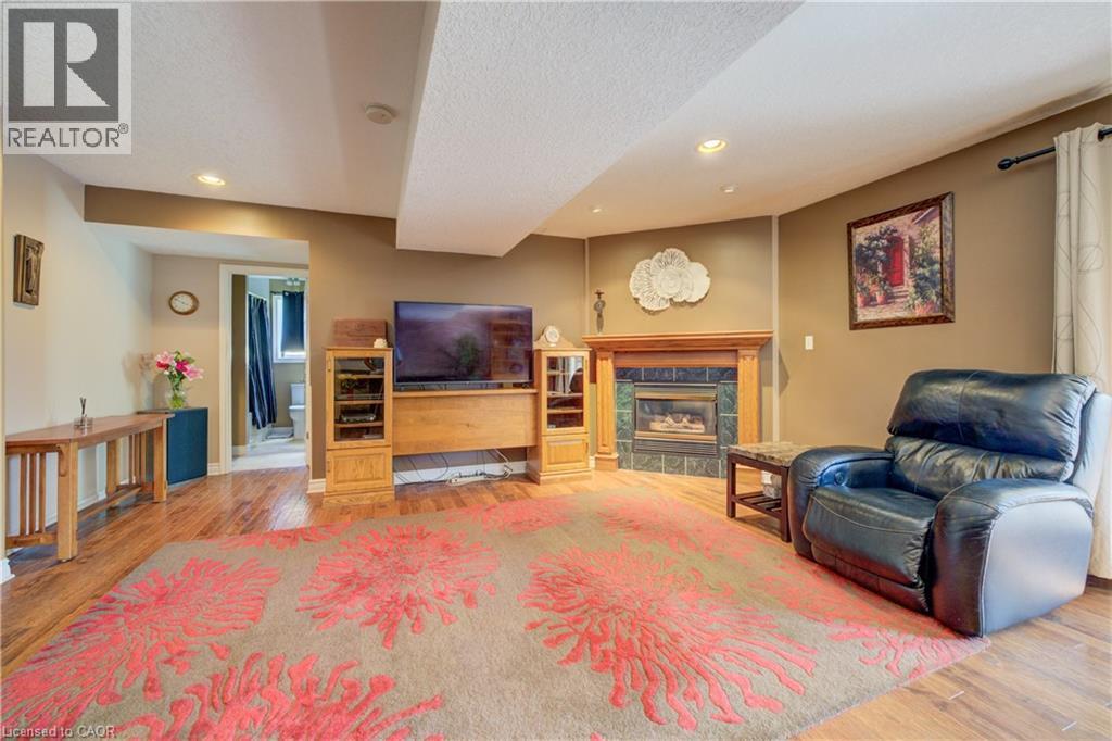Spacious living area featuring wood-finish flooring and recessed lighting - 599 Coldstream Drive, Waterloo, ON - Indoor Photo Showing Other Room With Fireplace