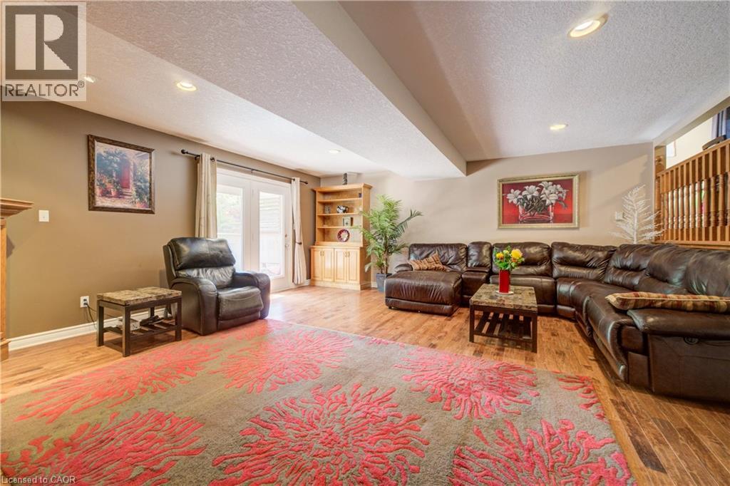 Spacious living area featuring wood-finish flooring and a built-in wood shelving unit - 599 Coldstream Drive, Waterloo, ON - Indoor Photo Showing Living Room