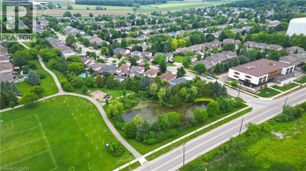 Aerial perspective showcasing a residential neighborhood with a variety of housing styles, established tree cover, and community amenities - 599 Coldstream Drive, Waterloo, ON - Outdoor With View