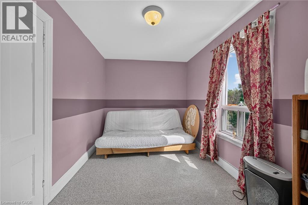 Carpeted room with a double-hung window, light fixture, and painted walls featuring a horizontal band - 230 Picton Street E, Hamilton, ON - Indoor