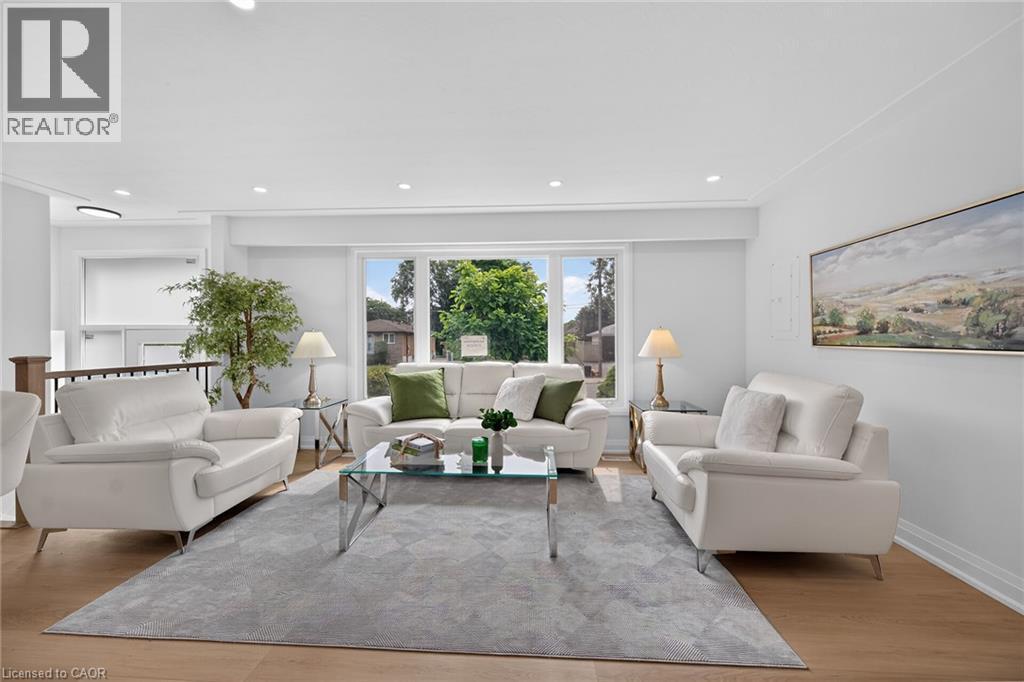 Expansive living area featuring light wood-finish flooring, recessed lighting, and a large picture window - 40 Purdy Crescent, Hamilton, ON - Indoor Photo Showing Living Room