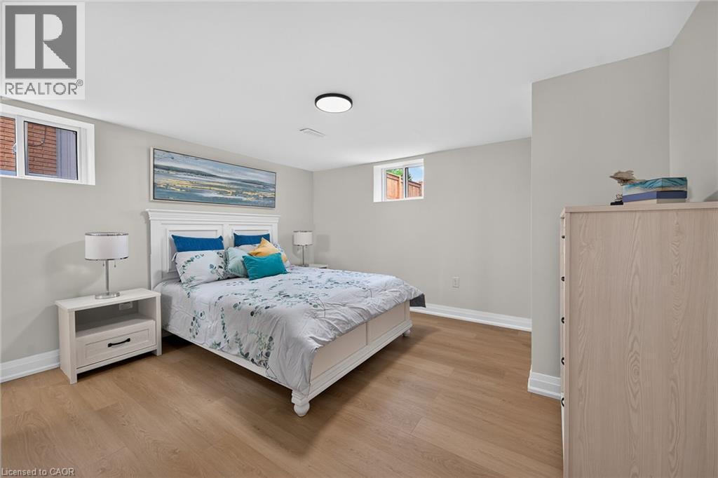 Wood-finish flooring with white baseboards, light gray painted walls, and white ceiling - 40 Purdy Crescent, Hamilton, ON - Indoor Photo Showing Bedroom