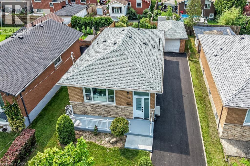Brick exterior with stone accents, covered front porch, asphalt driveway, and detached garage - 40 Purdy Crescent, Hamilton, ON - Outdoor