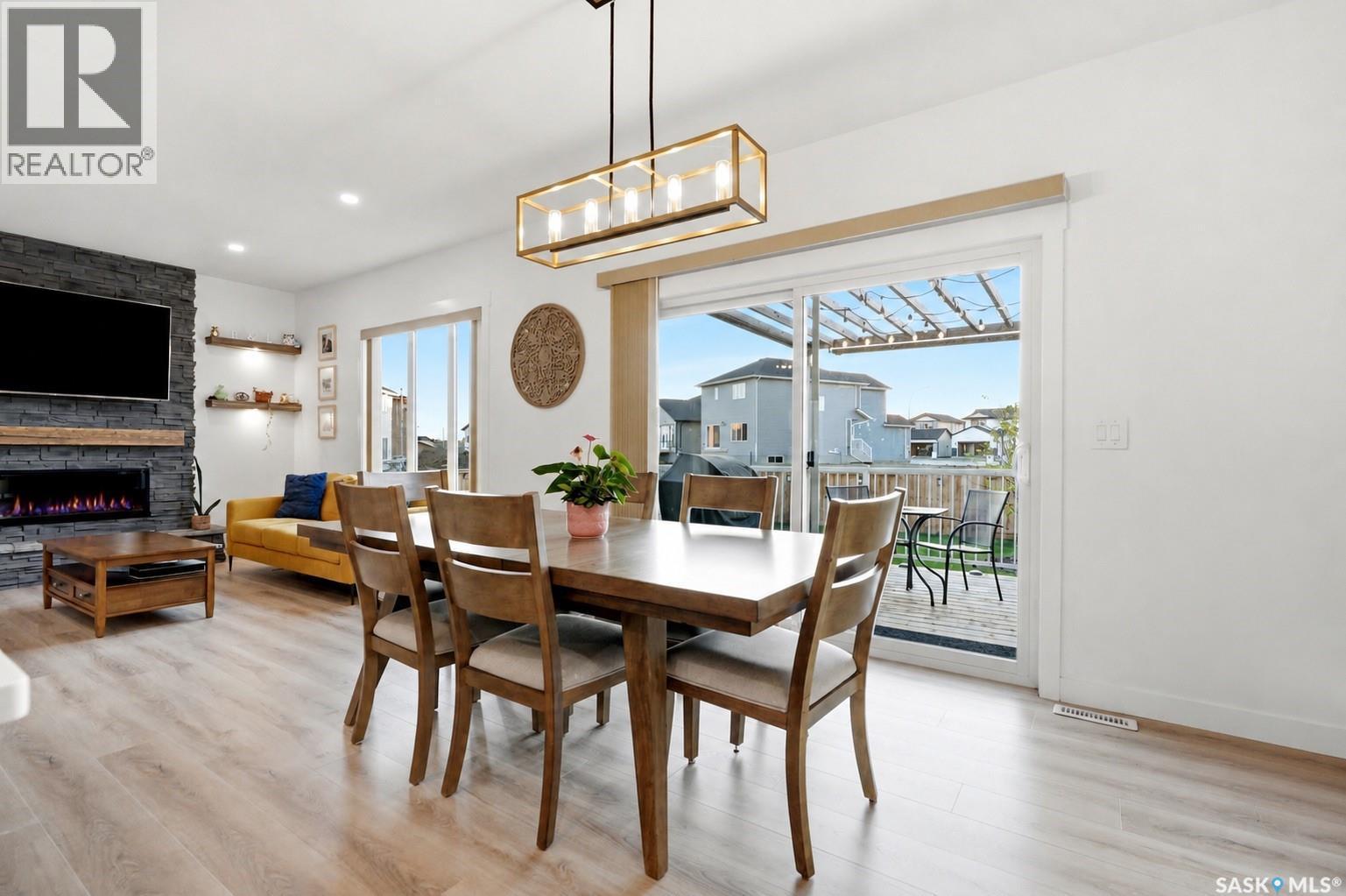 302 Chelsom Manor, Saskatoon, SK - Indoor Photo Showing Dining Room With Fireplace