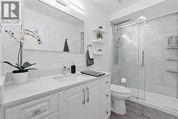 White vanity with a single basin, stainless steel faucet, and quartz countertop -