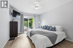 Wood-finish flooring throughout, sliding glass door with direct outdoor access, and a ceiling-mounted light fixture -