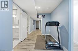 Hallway with wood-finish flooring, light blue walls, recessed lighting, and white trim -