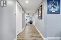 Hallway with wood-finish flooring, recessed lighting, and light gray painted walls -