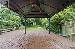 Expansive wooden deck with a covered gazebo featuring a built-in light fixture -