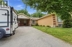 Brick exterior with an attached carport, bay window, and gabled roofline -
