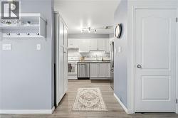 Light-toned wood-finish flooring, white paneled doors, and a built-in storage cabinet with hooks -