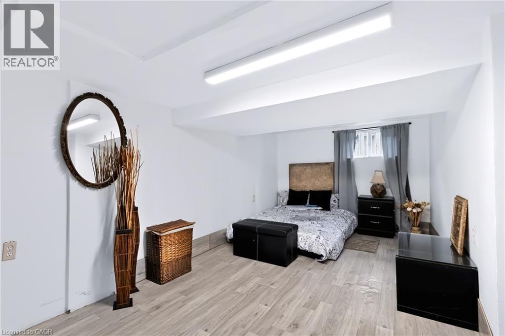 White walls and ceilings with light wood-finish flooring - 703 Brighton Avenue, Hamilton, ON - Indoor Photo Showing Bedroom