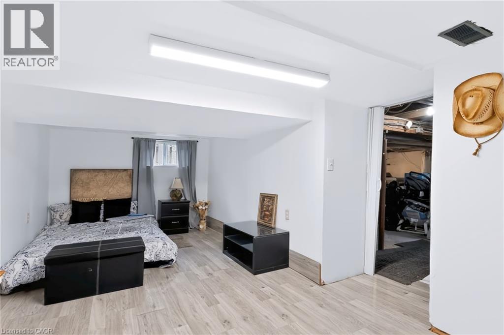 Light wood-finish flooring, white walls, recessed window, and overhead strip lighting - 703 Brighton Avenue, Hamilton, ON - Indoor Photo Showing Bedroom