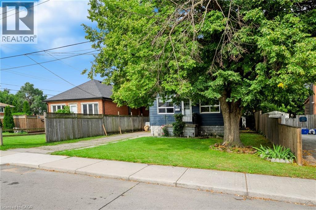 Deep blue siding exterior with white window trim - 703 Brighton Avenue, Hamilton, ON - Outdoor
