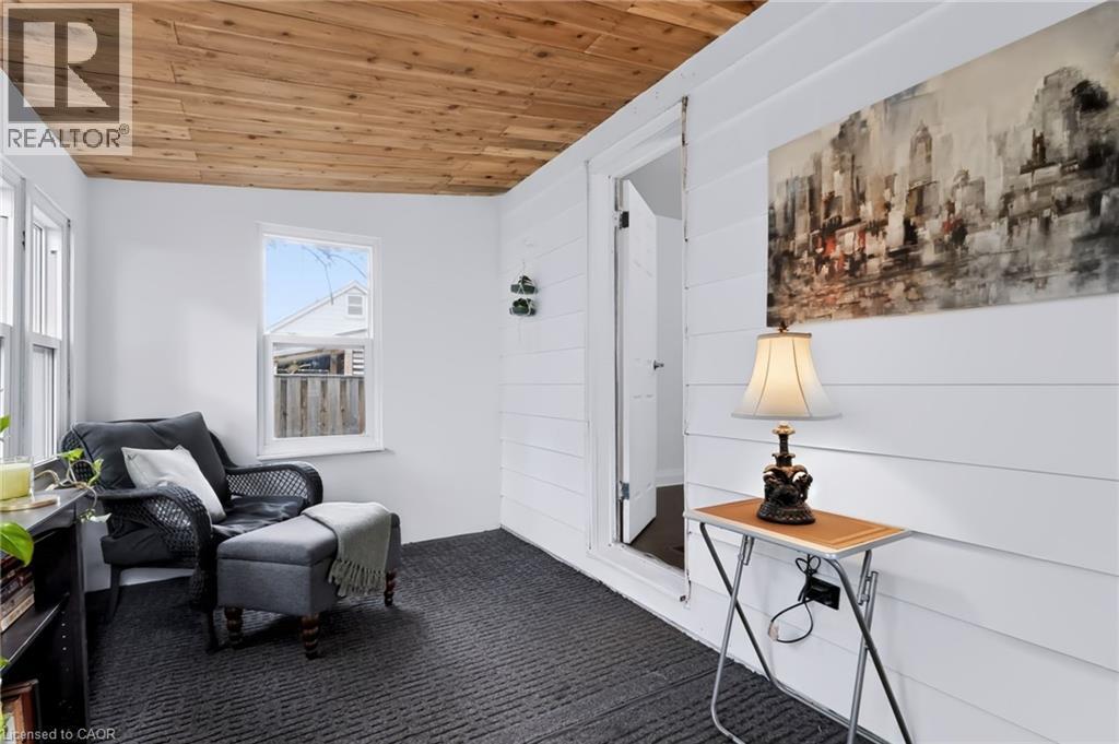 Wood-finish plank ceiling, white horizontal plank wall paneling, and dark patterned carpet flooring - 703 Brighton Avenue, Hamilton, ON - Indoor