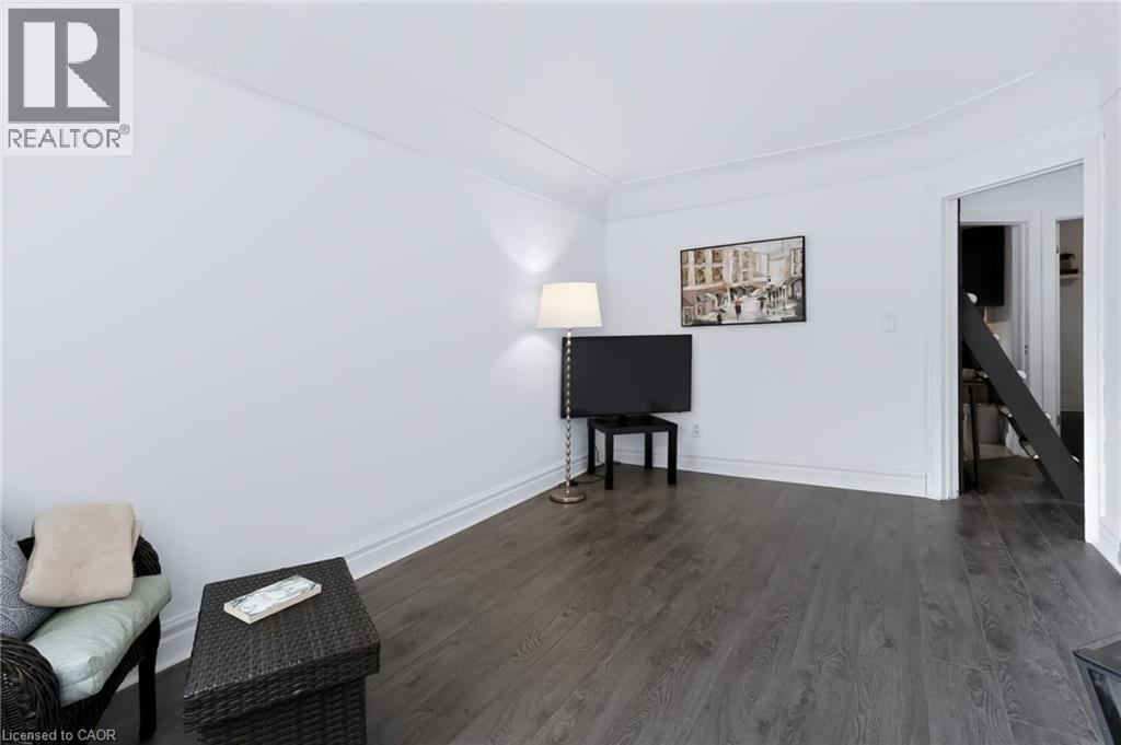 Wood-finish flooring with white baseboards, recessed wall lighting, and an open doorway - 703 Brighton Avenue, Hamilton, ON