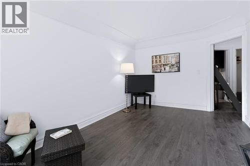 Wood-finish flooring with white baseboards, recessed wall lighting, and an open doorway - 703 Brighton Avenue, Hamilton, ON 