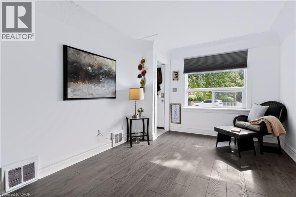 Wood-finish flooring, white walls, and a large window with natural light - 703 Brighton Avenue, Hamilton, ON - Indoor