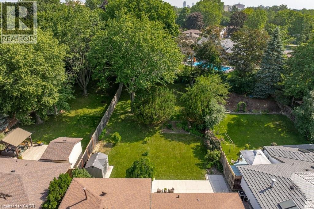 Expansive green space with mature trees, fenced perimeter, and a detached shed - 64 Warren Road, Kitchener, ON - Outdoor