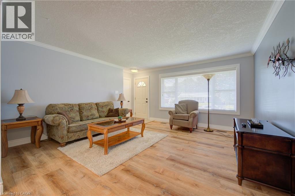 Light wood-finish flooring, white trim, and a large window with blinds - 251 Union Street E, Waterloo, ON - Indoor Photo Showing Living Room