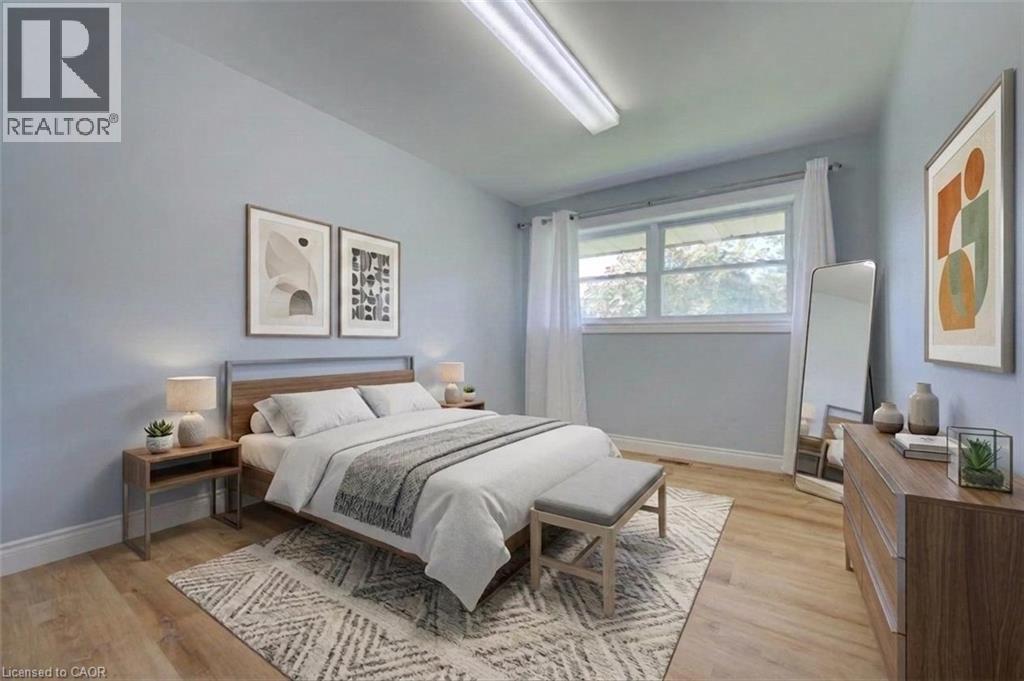 Light wood-finish flooring, a large window with white trim, and light blue walls - 251 Union Street E, Waterloo, ON - Indoor Photo Showing Bedroom