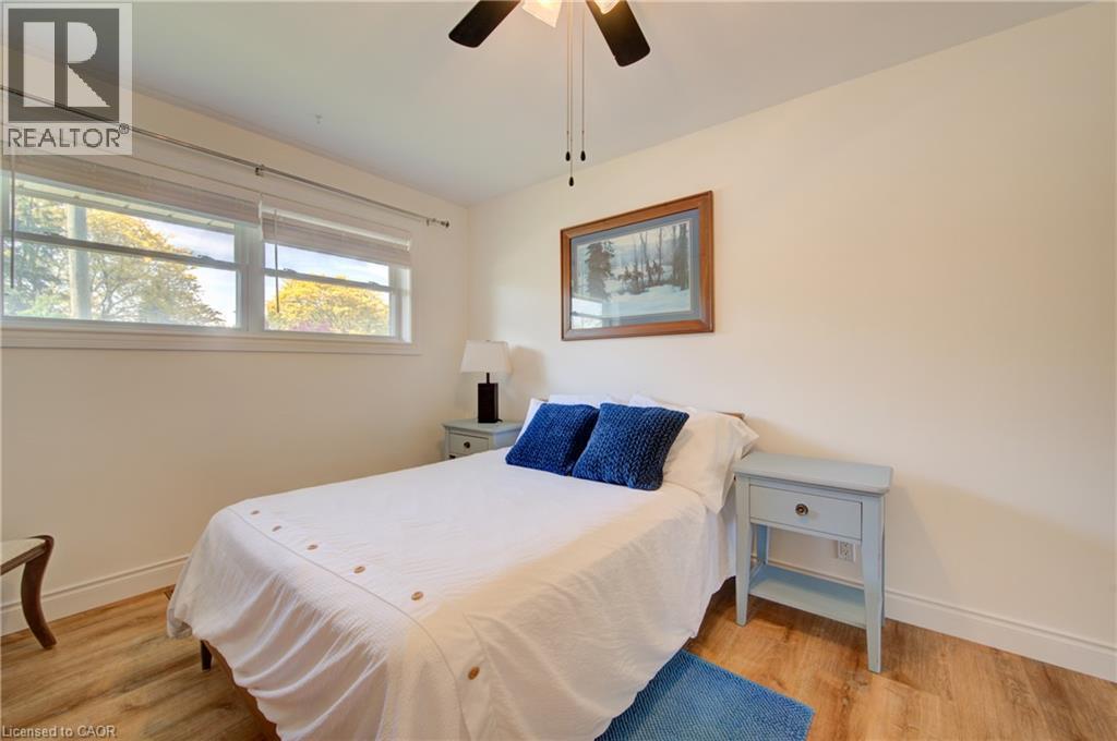 Wood-finish flooring, ceiling fan, and two windows with blinds - 251 Union Street E, Waterloo, ON - Indoor Photo Showing Bedroom